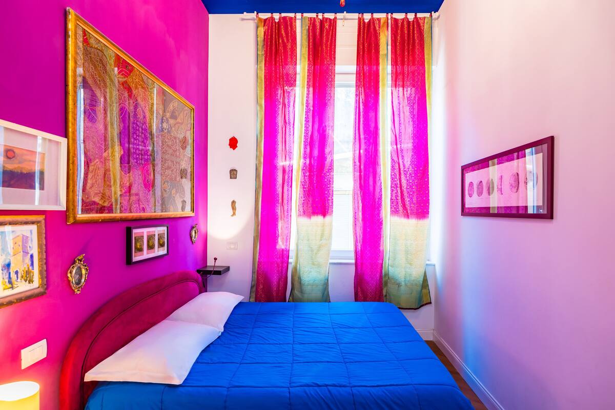 Une chambre à coucher avec un lit, des rideaux et des éléments de décoration murale.