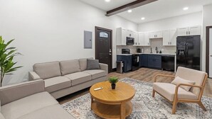 Un apartamento moderno con sala de estar, kitchenette y comedor.