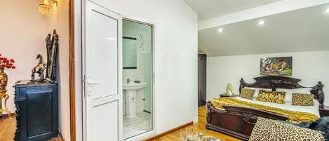 Un amplio salón con una cama grande, una mesa de centro de vidrio y una araña.