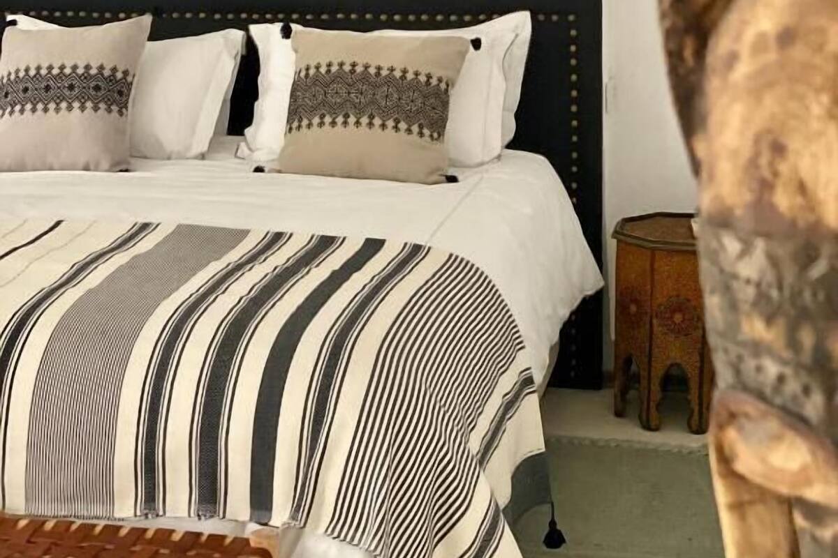 Une chambre à coucher avec un lit, des oreillers et une lanterne fixée au mur.