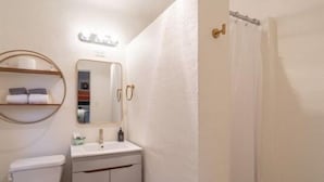Une salle de bain avec des toilettes, un lavabo et un miroir.