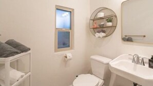Une salle de bain avec des toilettes, un lavabo et une fenêtre donnant sur un beau paysage.