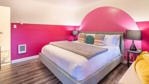 Une chambre à coucher avec un lit, une table de chevet et une lampe.