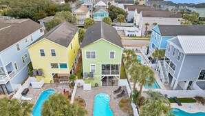 A residential area with houses, a swimming pool, and a small patio area. - Surfside Retreat w/ Pool & Elevator Access (Surfside Beach)