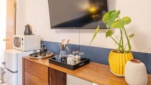 A kitchenette with a microwave, coffee maker, and a tray with coffee cups. - b. under the sea #2 King bedroom (Bandon)