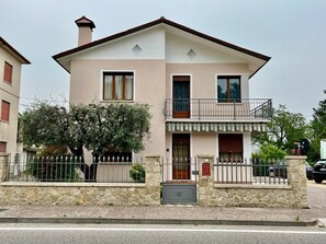 A two-story building with a balcony, stone facade, and a small tree in front. - Fully equipped & remodeled 2-bedroom apartment (sleeps up to 6ppl) (Mussolente)