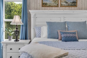 A bedroom with a bed, pillows, a nightstand, a lamp, and a window with curtains. - 5 BR Houston Retreat - Private Loft + Huge Deck - Sleeps 12 (Houston)