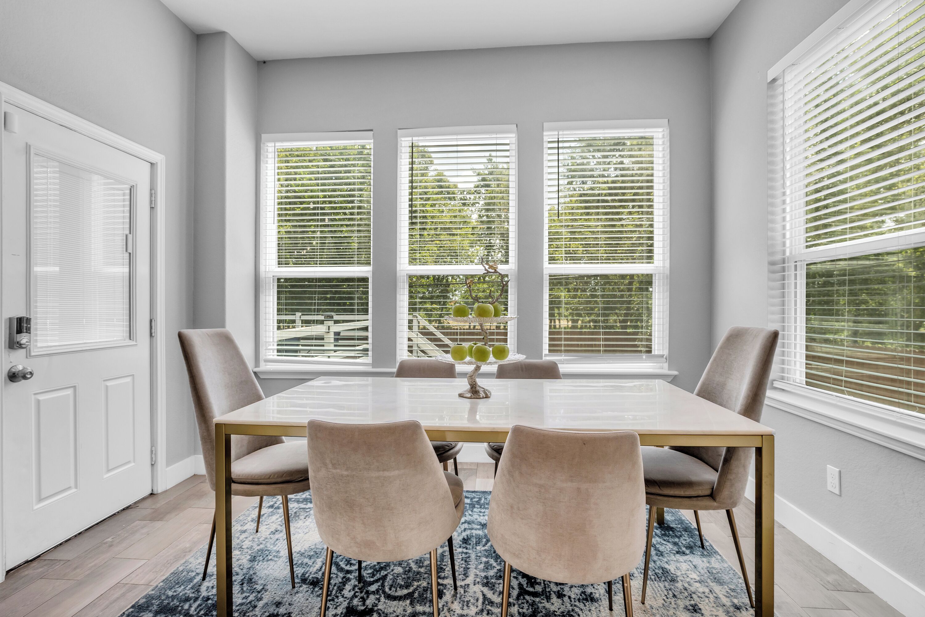 Dining room – bright table seating beside large backyard-facing windows.