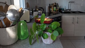 Una cocina moderna con una isla central, horno empotrado y campana extractora de acero inoxidable.