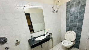 Un baño con lavabo, espejo, inodoro y paredes de azulejos.