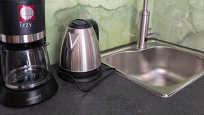 Eine Küche mit Kaffeemaschine, Wasserkocher und Spüle.