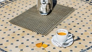 A table with a coffee cup, a spoon, and a napkin on a tiled surface. - HOTEL DIESEL (Bucharest)
