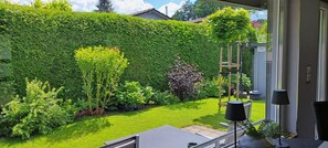 A well-maintained garden with a variety of plants and a neatly trimmed hedge.