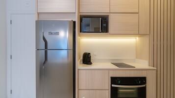 A modern kitchen with a stainless steel refrigerator, a microwave, a coffee maker, and a dishwasher.