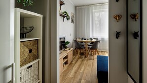 A modern kitchen with white cabinets, a wooden countertop, and a built-in stove. - RentPlanet - Apartament Zdrowa (Wrocław)