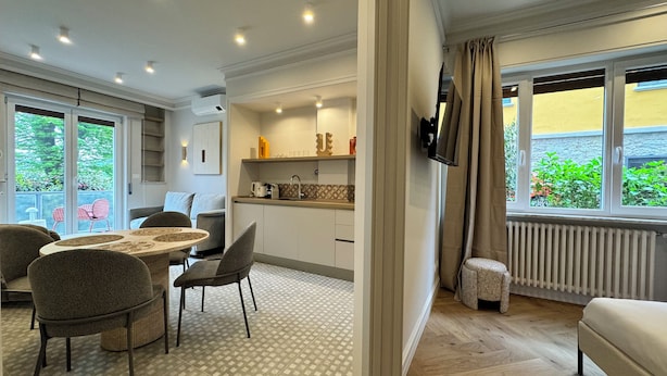 Una cocina moderna con comedor, televisor montado en la pared y vistas a zonas verdes.