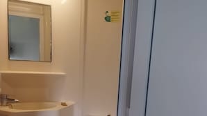 A small, compact bathroom with a toilet, sink, and mirror. - fasthotel troyes  (Barberey-Saint-Sulpice)