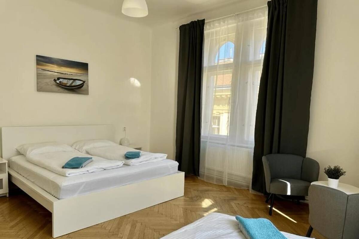 Une chambre d’hôtel moderne équipée d’un lit, d’une chaise, d’un bureau et d’une fenêtre avec des rideaux.