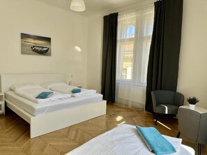 A modern hotel room with a bed, a chair, a desk, and a window with curtains. - Welcome Hostel & Apartments Praguecentre (Prague)