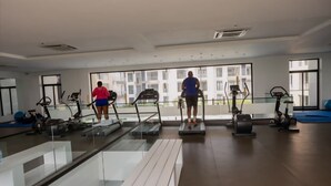 Ett gym med löpband, motionscyklar och en vägg av glas.