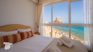 A hotel room with a large bed, a view of the beach, and a rocky outcrop in the distance. - CostaBlancaDreams - Europa 2 in Calpe (Calpe)