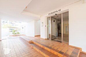 A modern building entrance with a tiled floor, a glass door labeled "EUROPA-11", and a small plant by the entrance. - CostaBlancaDreams - Europa 2 in Calpe (Calpe)