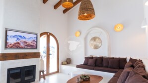 Una sala de estar moderna con chimenea, un televisor de pantalla plana grande, un sofá y una mesa de centro.