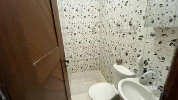 Chuveiro, toalhas de banho, sabonete, papel higiênico