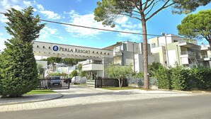A resort entrance with a sign reading "PERLA RESORT" and a gated driveway. - Perla Resort (Ishëm)