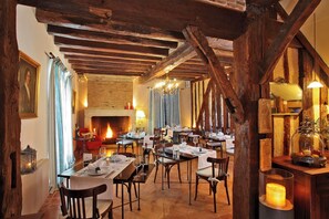 A restaurant with wooden beams, a fireplace, and tables set for dining. - Hameau du jardin Fleuri near Bergerac - 10 gîtes, sleeps 40 (Bosset)