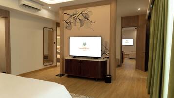 Une chambre d’hôtel avec un lit, un téléviseur posé sur un meuble en bois, un miroir et un téléviseur fixé au mur.