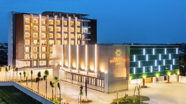 Un hotel con fachada moderna, varios pisos y una entrada bien iluminada.