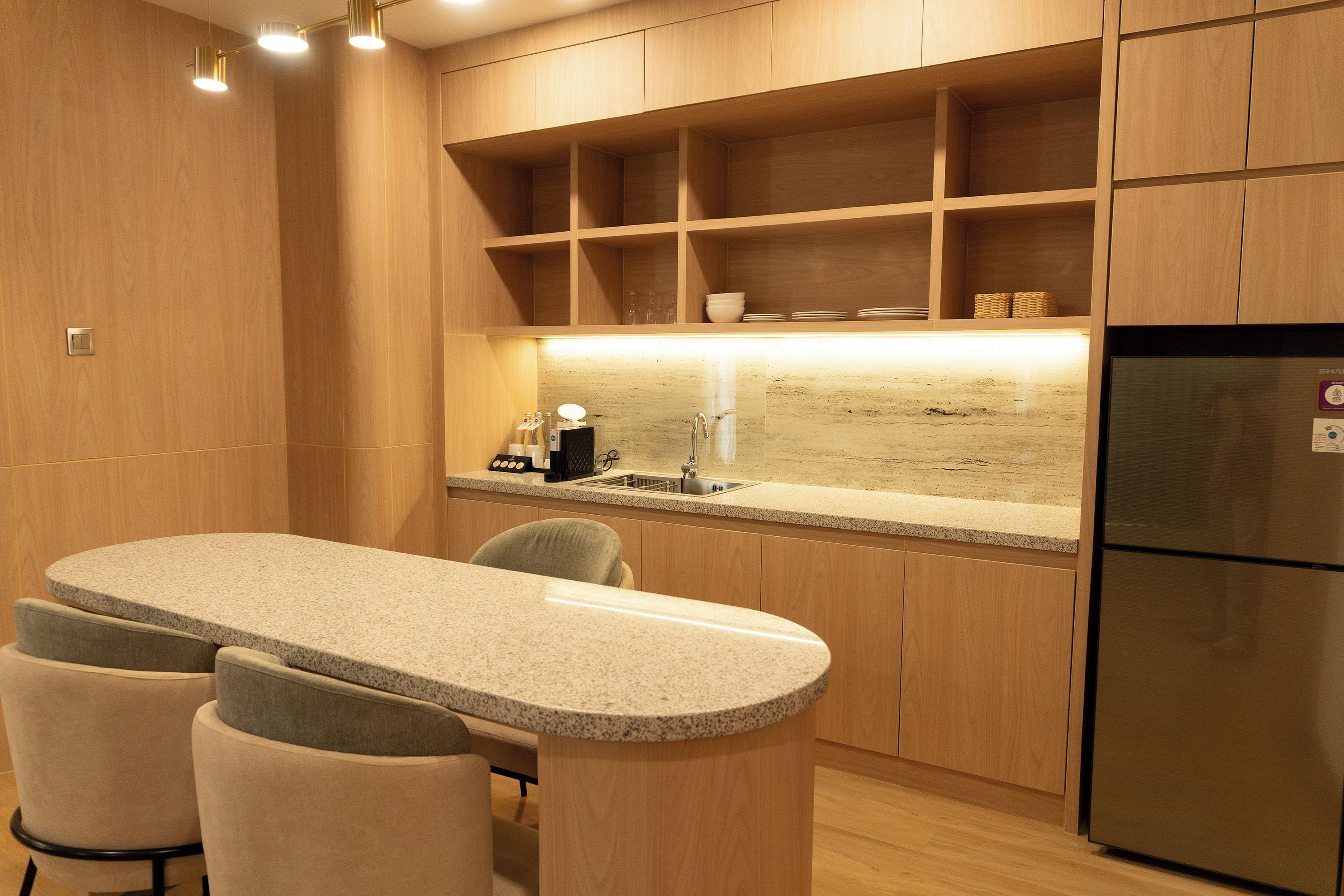 A modern kitchen with wooden cabinets, a granite countertop, and a built-in refrigerator.