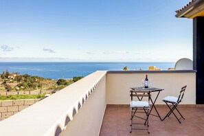 A balcony with a table and chairs, overlooking a coastal view. - Home2Book Villa Jazmín Real Heated pool & views (Arafo)