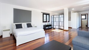 Una camera d'albergo moderna con un letto grande, una scrivania, una sedia e vista sulla città.