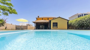 Una piscina con una casa sullo sfondo.