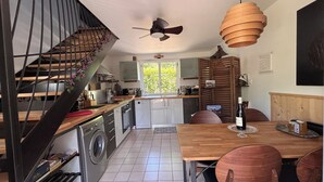 Una cocina con comedor, lavadora y ventilador de techo.