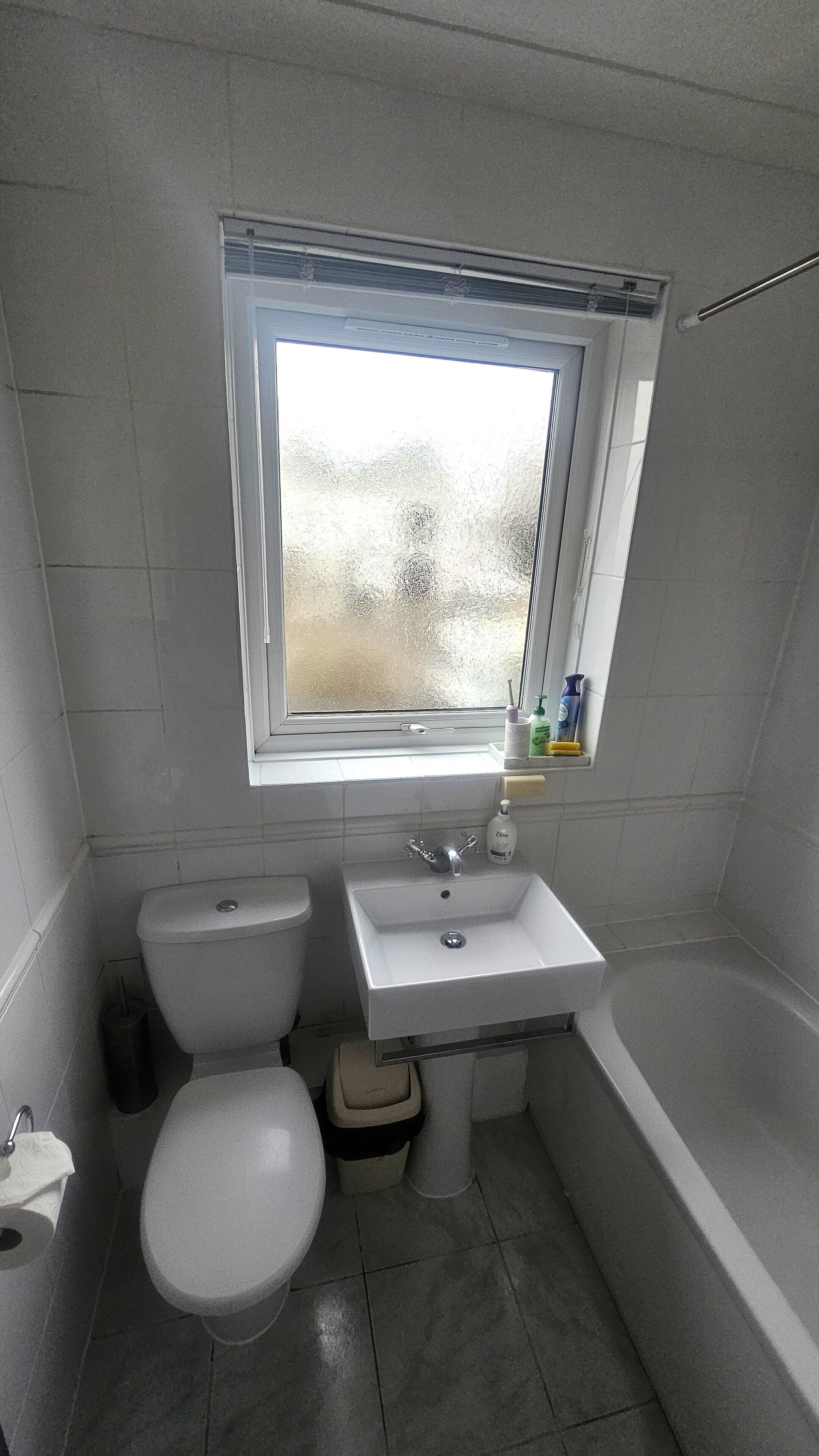 Et badeværelse med toilet, håndvask og badekar.