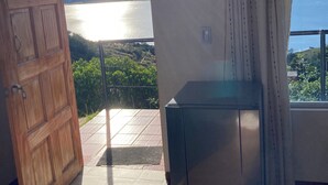 Una stanza con una porta in legno, una vetrina e vista su un lago e montagne.