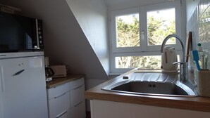 Eine Küche mit Mikrowelle, Toaster und Spüle.