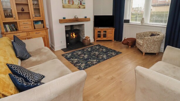 A living room with a fireplace, a television, and a sofa. - 23 Northumbria Terrace (Morpeth)