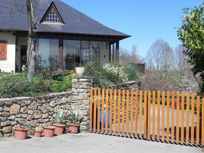 Une maison avec un mur en pierre et une clôture en bois.
