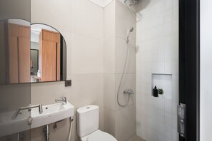 Een moderne badkamer met een wit wastafelmeubel, toilet en douche.