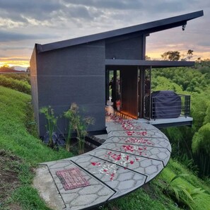 A modern building with a curved pathway leading to a covered area. - Maranatha Grotto&Boutique. Glamorous Lodge & Cycladic Grotto-Type Hydro Spa (Pereira)