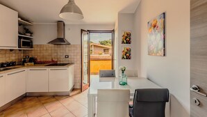 A modern kitchen with white cabinets, a built-in microwave, and a large window.