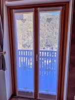 Una puerta de madera con marco, que tiene dos paneles de vidrio, cada uno con un diseño de corazón en la parte superior e inferior.