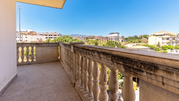 A balcony with a balustrade overlooking a residential area with buildings and greenery. - Cariddi (Caulonia)