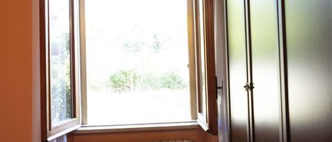 A room with a window, radiator, and wardrobe.