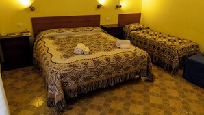 Una habitación de hotel con dos camas, una mesita de noche y una pequeña mesa.