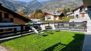 A hotel with a grassy patio, outdoor seating, and mountain views. - La Maison De L'Adret (Saint-Pierre)